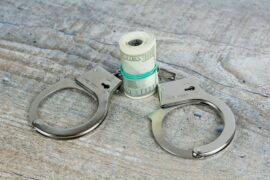 Sex trafficking initiatives aim to prevent trafficking, support survivors, and disrupt the traffickers. In this photo, we see a pair of handcuffs and a roll of money.