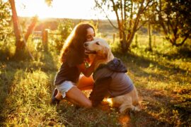 Sex trafficking survivors can heal through animal-assisted therapy as shown in the photo of a teenage girl sitting in the grass, hugging her golden retriever.