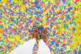 One way to develop emotional intelligence is to celebrate successes. Show in this image is a pair of feet surrounded by colorful confetti.